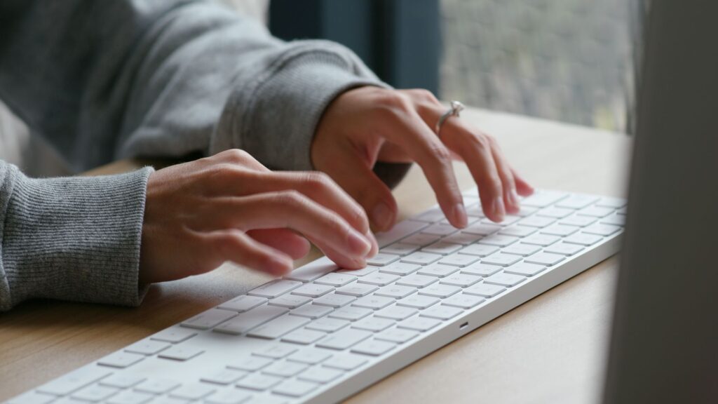Person typing on wireless computer keyboard.
