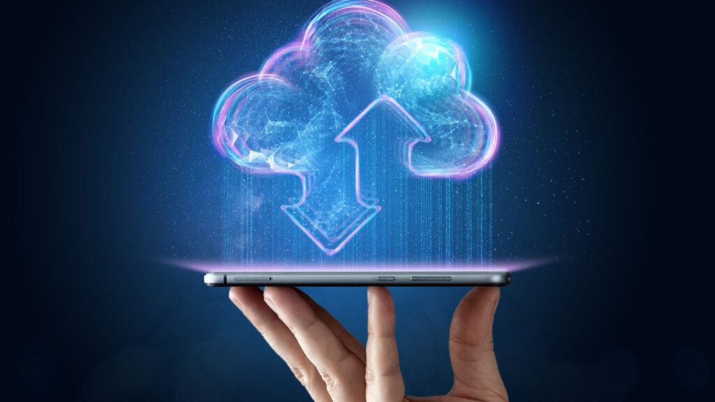 Hand holding tablet with digital cloud above it.