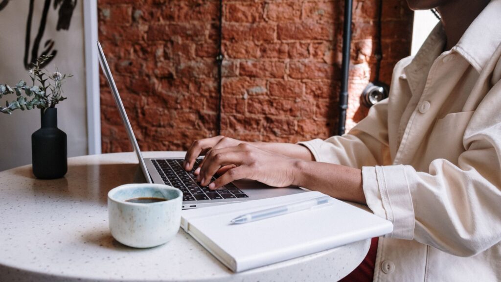 Person writing blog post on laptop.
