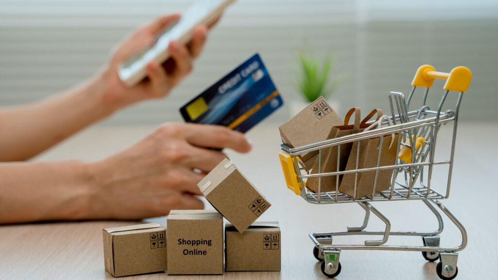 Miniature shopping cart with miniature boxes in it.
