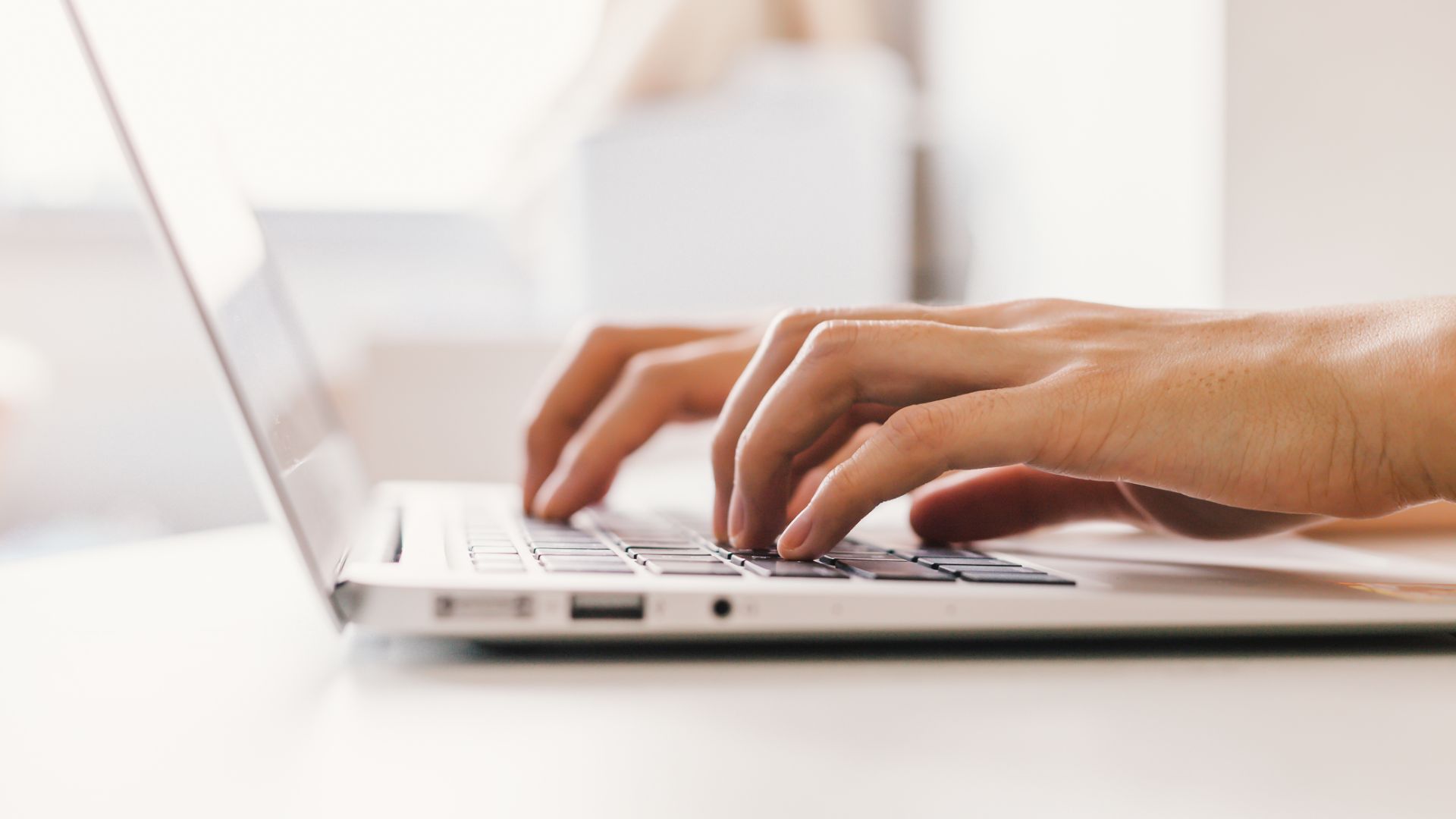 Hands typing on laptop.
