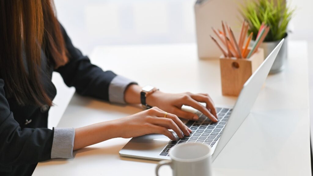 Woman typing content ideas on laptop.