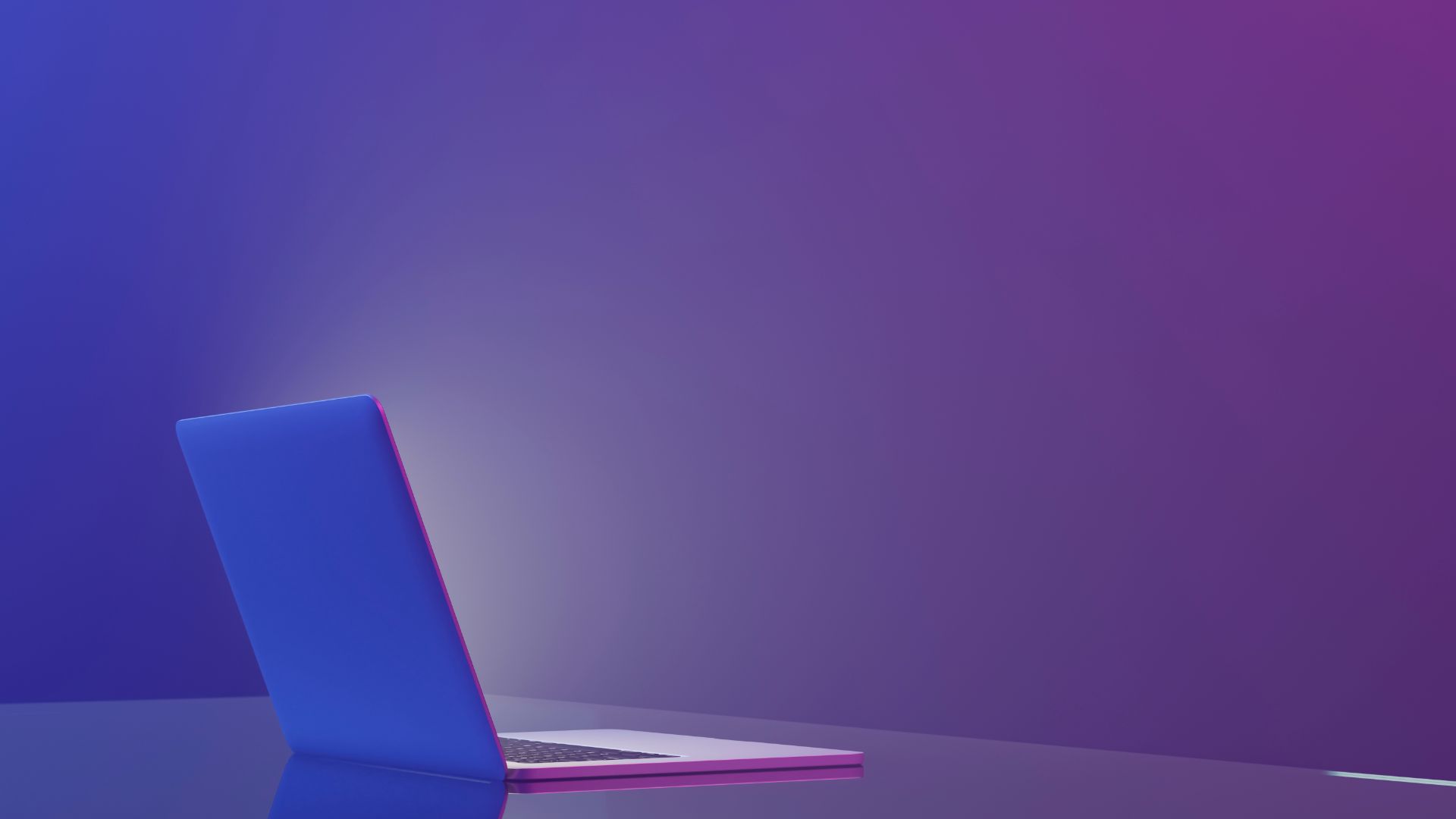 Laptop on table in purple lighting.