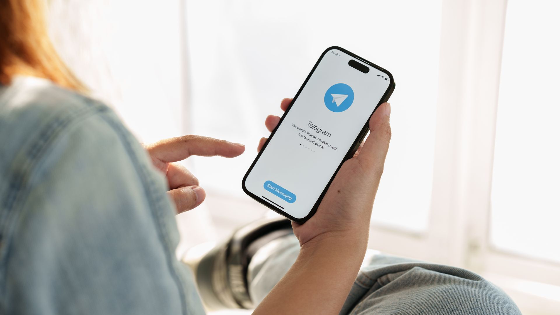 Telegram user holding smartphone.