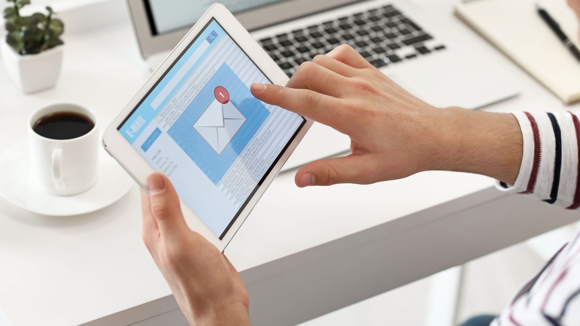 Person holding tablet with email program on the screen.