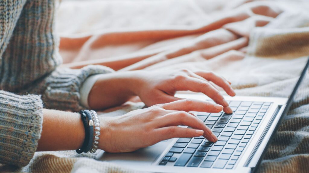 Person typing on laptop keyboard.